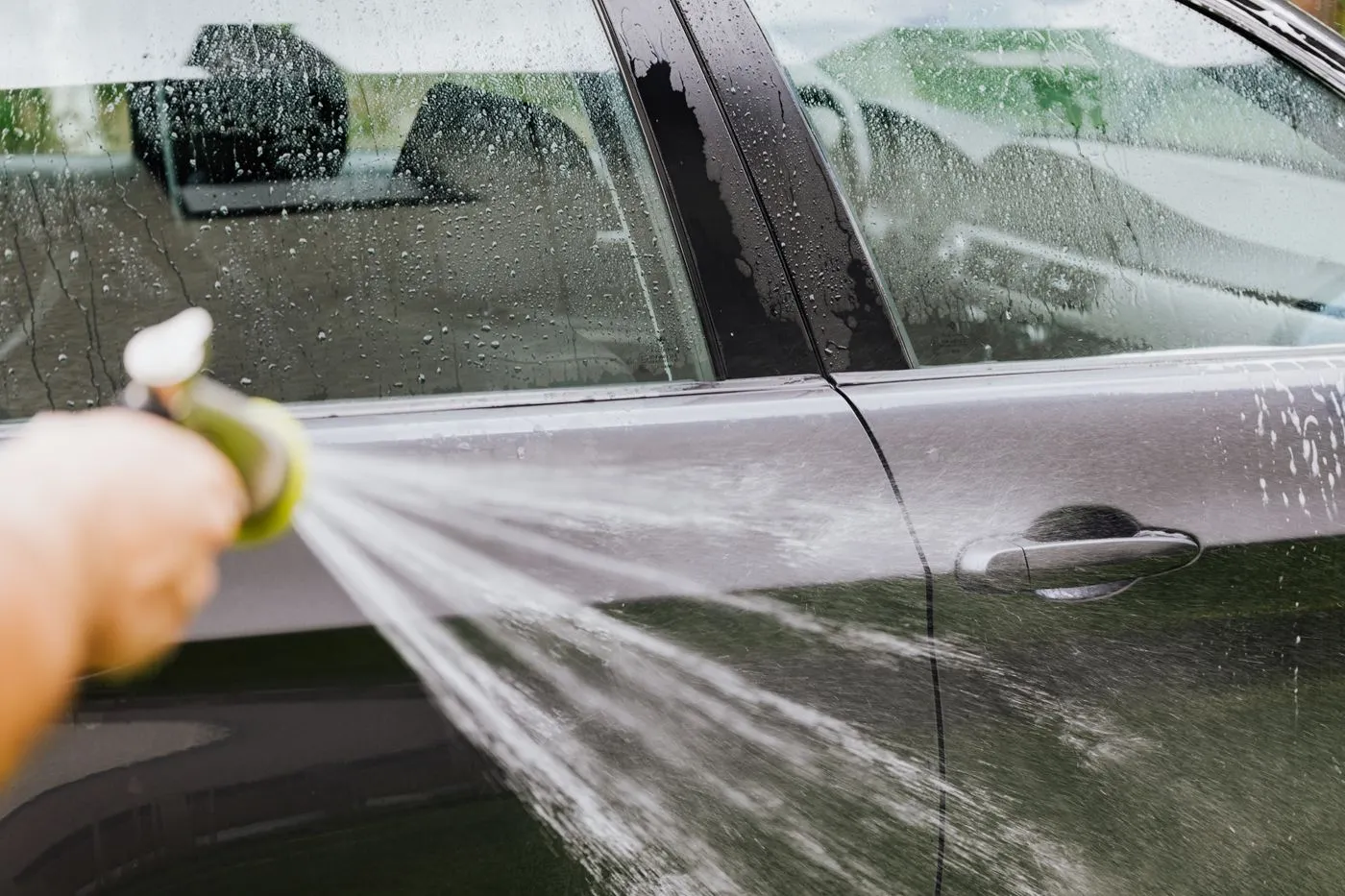 Water rinsing off the bodywork of a dark car