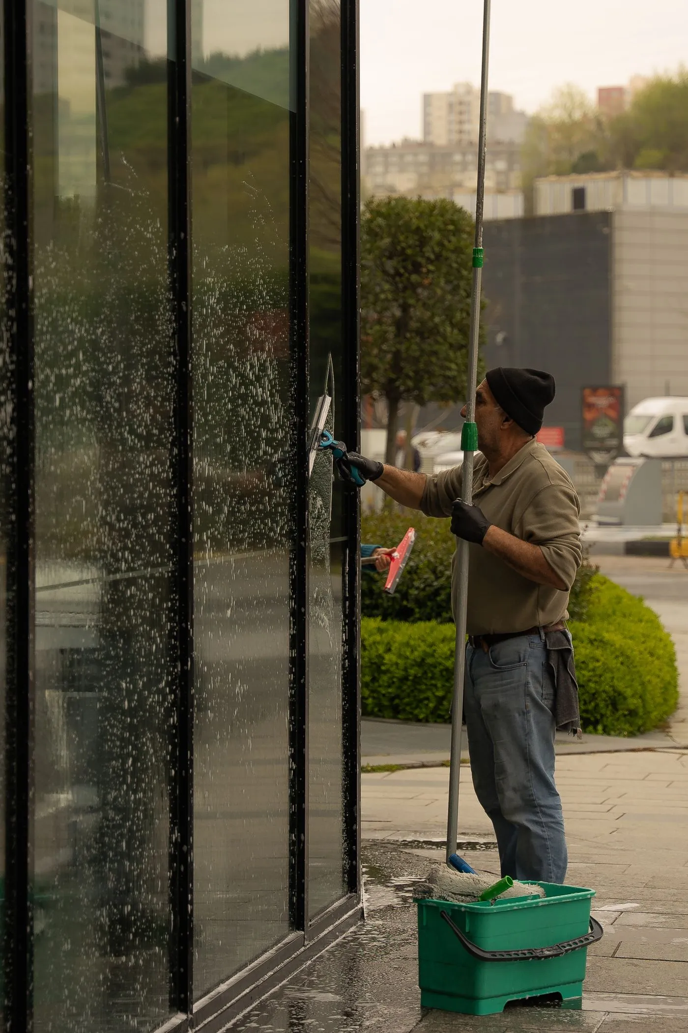 Professional window cleaner working on a commercial glass facade